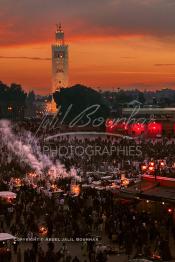 Image du Maroc Professionnelle de  Au coucher du soleil et même un peu avant la foule envahi la fameuse Place Jemaa El Fana qui se métamorphose en un gigantesque restaurant en plein air grâce aux nombreux stands et gargotes qui s'y installent sur ce lieu mythique au centre de la médina de Marrakech. Au fond le minaret de la Koutoubia, Samedi 26 Février 2005. (Photo / Abdeljalil Bounhar)

